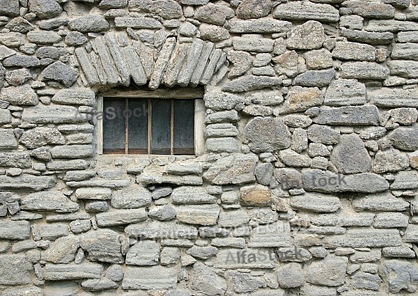 Old window by a simple stone.