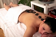 Woman in wellness and spa setting having a hot stone therapy session