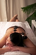 Woman in wellness and spa setting having a hot stone therapy session