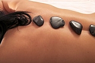 Woman in wellness and spa setting having a hot stone therapy session