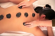 Woman in wellness and spa setting having a hot stone therapy session