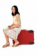 Young girl packs her bags for traveling. White background