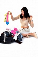 Young girl packs her bags for traveling. White background