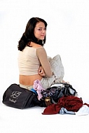 Young girl packs her bags for traveling. White background