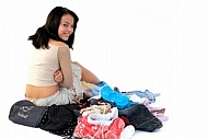 Young girl packs her bags for traveling. White background