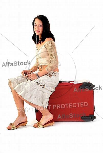 Young girl packs her bags for traveling. White background