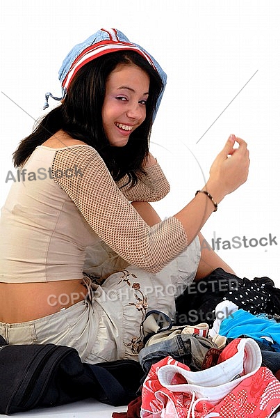 Young girl packs her bags for traveling. White background