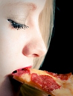 Blonde girl eating Pizza.